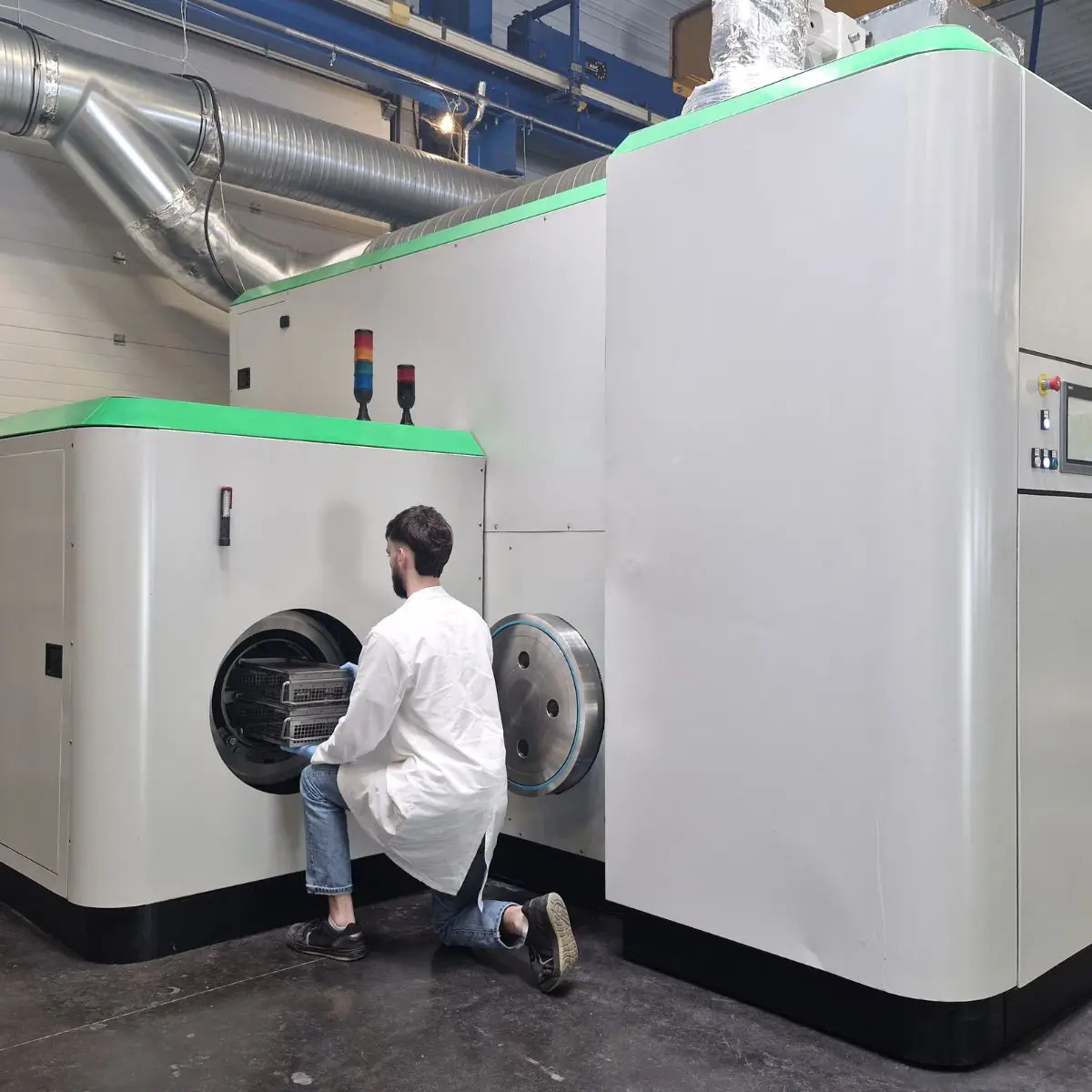 Personne sortant les pièces d'un autoclave suite à leur nettoyage au CO2 supercritique